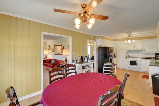 dining room featuring ornamental molding, ceiling fan, and light wood-type flooring