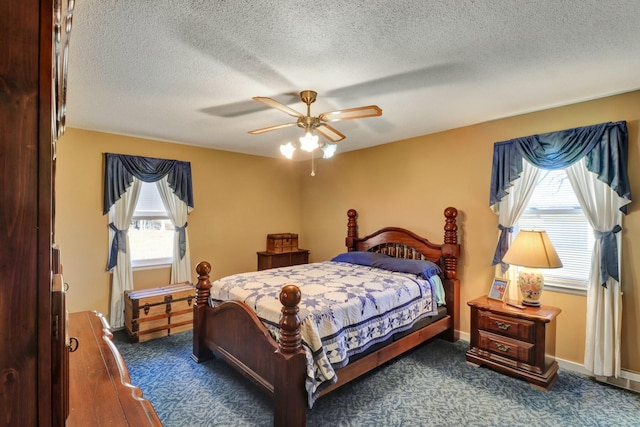 bedroom with a textured ceiling, ceiling fan, and multiple windows