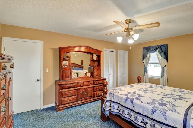 carpeted bedroom featuring a textured ceiling, two closets, and ceiling fan