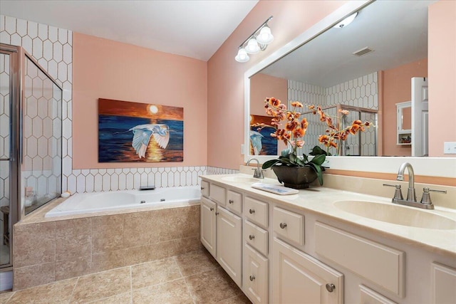 bathroom with visible vents, a sink, a shower stall, and a garden tub