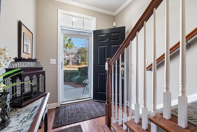 foyer entrance featuring baseboards, stairway, crown molding, and wood finished floors