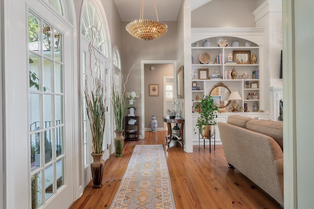 3948 Gift Blvd, Johns Island, SC 29455 - hallway featuring light wood-style flooring, baseboards, a high ceiling, a chandelier, and built in features