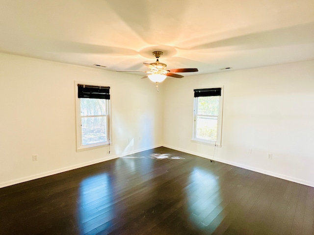 spare room with dark hardwood / wood-style flooring and ceiling fan