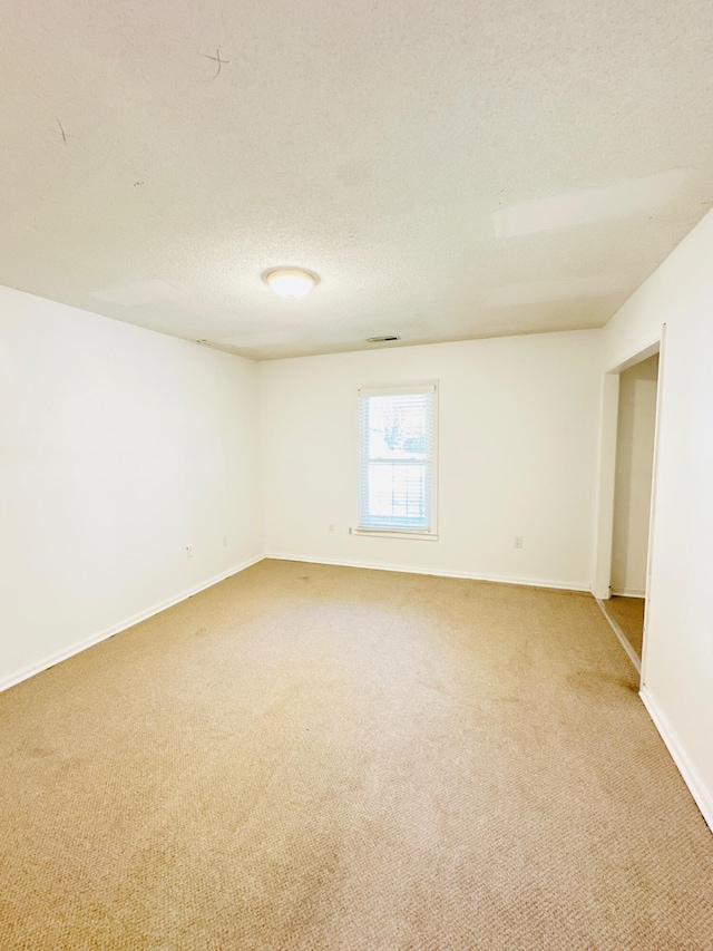 unfurnished room featuring carpet flooring and a textured ceiling