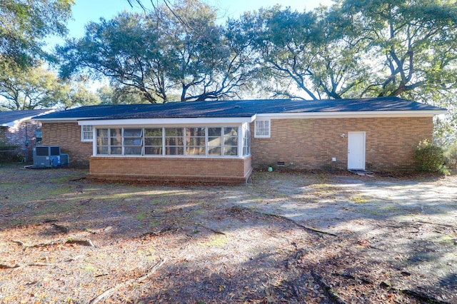 back of house featuring crawl space, brick siding, and a sunroom