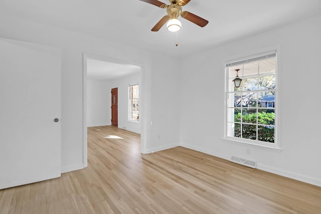 unfurnished room with baseboards, a healthy amount of sunlight, visible vents, and light wood-type flooring