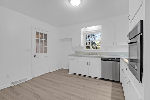 kitchen with visible vents, white cabinetry, light wood-style floors, appliances with stainless steel finishes, and light countertops