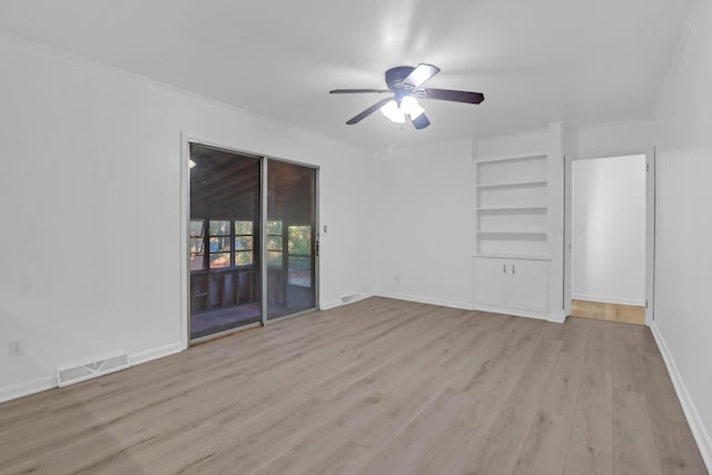 unfurnished room with built in shelves, wood finished floors, baseboards, visible vents, and ceiling fan