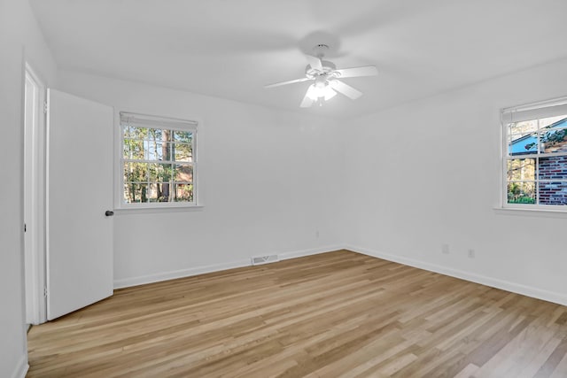 unfurnished room with light wood-type flooring, baseboards, and visible vents