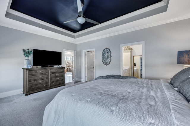 carpeted bedroom with ensuite bathroom, crown molding, and a raised ceiling