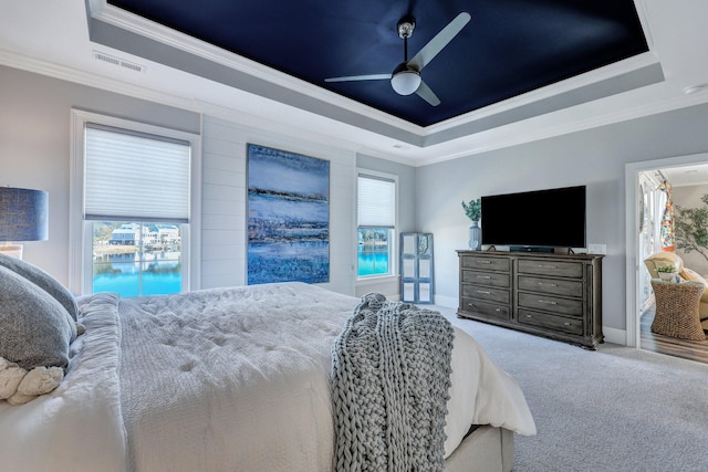 bedroom featuring crown molding, carpet floors, a ceiling fan, a raised ceiling, and visible vents