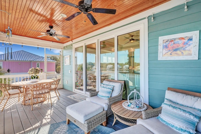 wooden deck with outdoor dining space and ceiling fan