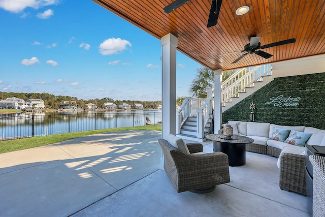 view of patio featuring an outdoor hangout area, a water view, stairway, and a ceiling fan