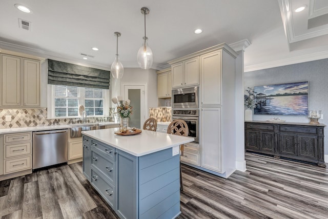kitchen featuring light countertops, crown molding, a sink, visible vents, and appliances with stainless steel finishes
