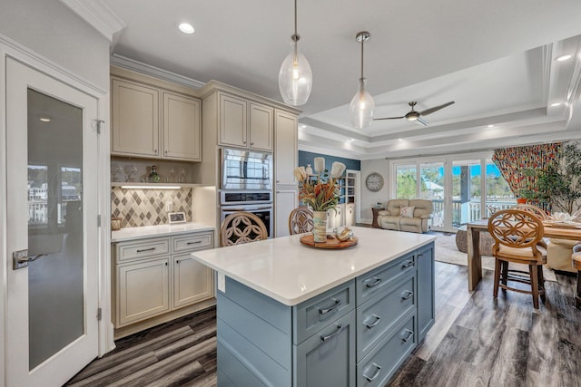kitchen featuring crown molding, gray cabinets, a raised ceiling, ceiling fan, and appliances with stainless steel finishes