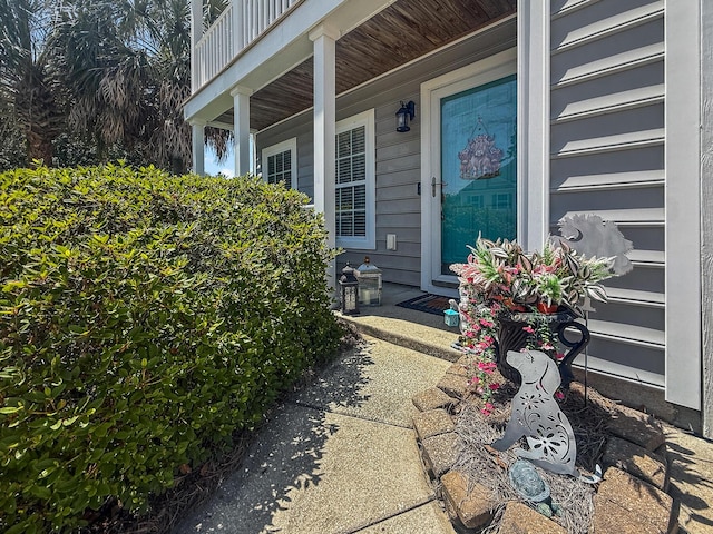 doorway to property with covered porch and a garage