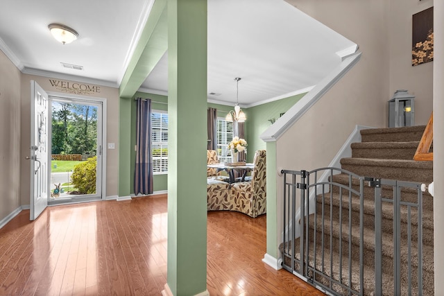 foyer with crown molding, stairway, wood finished floors, and baseboards