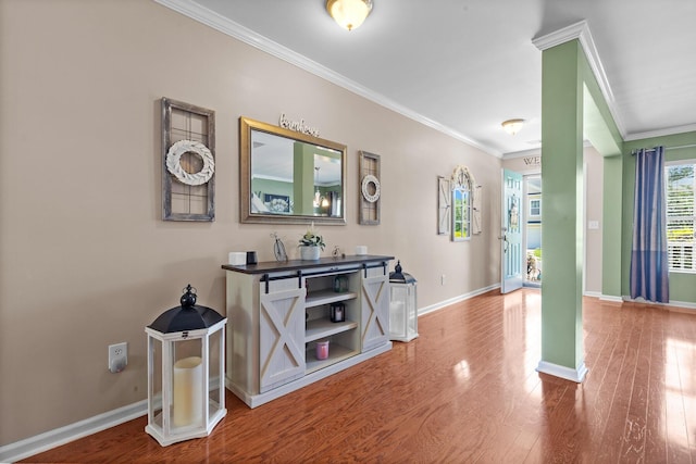 corridor with ornamental molding, wood finished floors, and baseboards