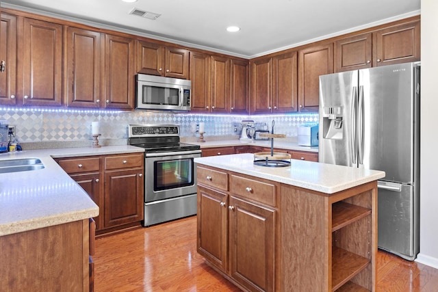 kitchen featuring appliances with stainless steel finishes, open shelves, light countertops, backsplash, and light wood-type flooring