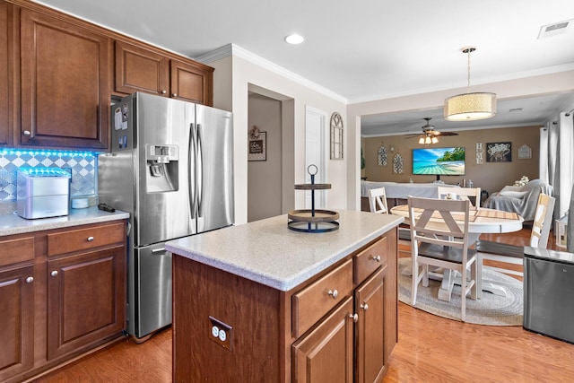 kitchen with stainless steel fridge with ice dispenser, ornamental molding, light wood finished floors, open floor plan, and a center island