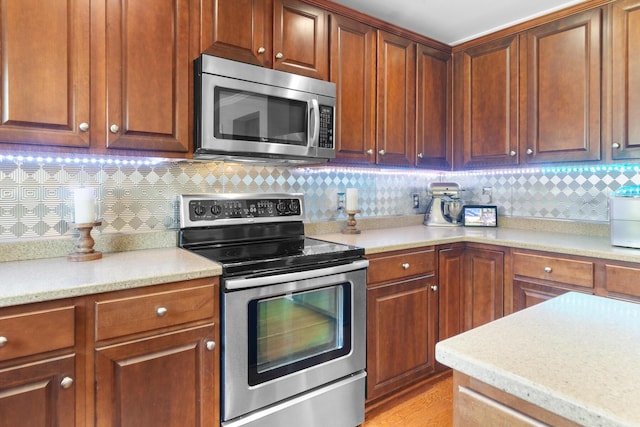kitchen with appliances with stainless steel finishes, light countertops, and tasteful backsplash