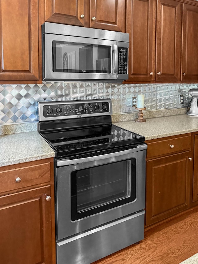 kitchen with stainless steel appliances, light countertops, and tasteful backsplash