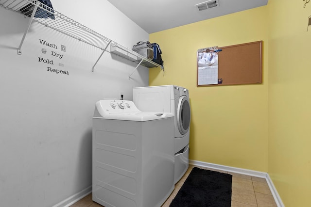 laundry room with washer and clothes dryer, baseboards, and light tile patterned floors