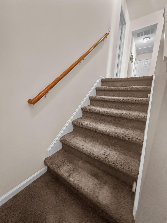 stairs featuring carpet flooring and baseboards