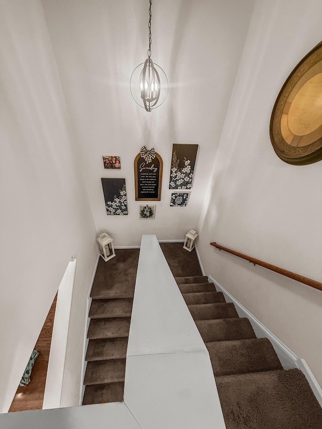 stairs with a chandelier and baseboards