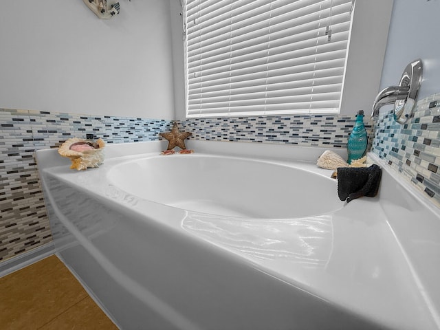 bathroom featuring tile patterned flooring and a garden tub