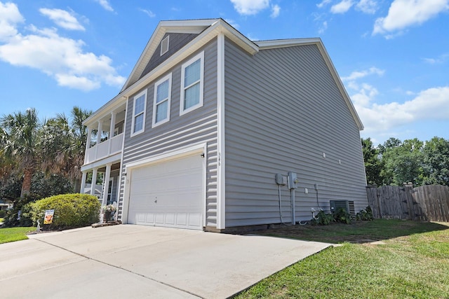 view of side of property featuring an attached garage and concrete driveway