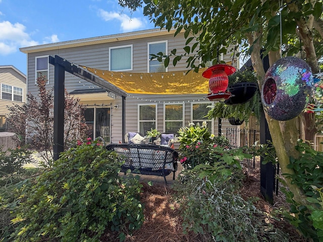 back of property with fence and central AC