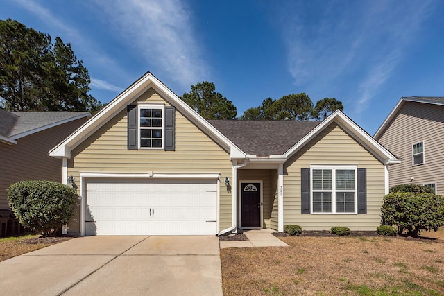 view of front of home featuring a shingled roof, a front yard, concrete driveway, and an attached garage