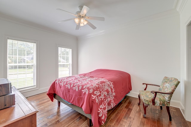 bedroom featuring crown molding, multiple windows, wood-type flooring, and ceiling fan