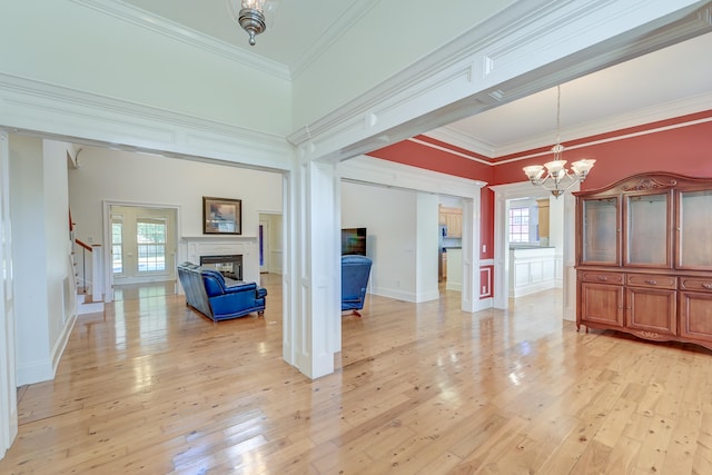 interior space with ornamental molding, a wealth of natural light, and light hardwood / wood-style floors