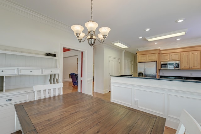 kitchen featuring light wood-type flooring, decorative light fixtures, appliances with stainless steel finishes, and a chandelier