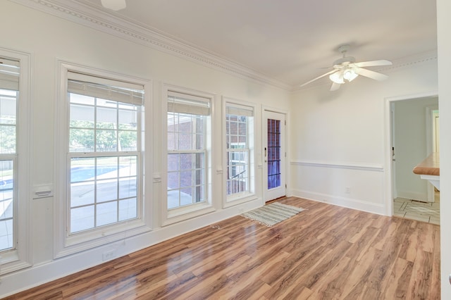 unfurnished room featuring crown molding, wood-type flooring, and ceiling fan