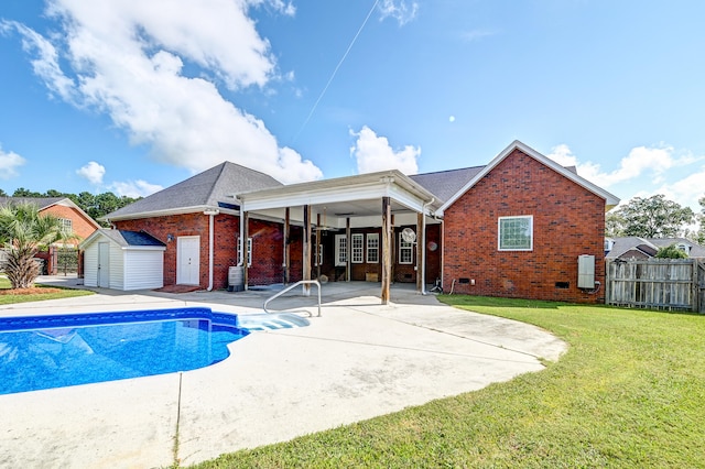 back of property with a fenced in pool, a lawn, a storage unit, and a patio area