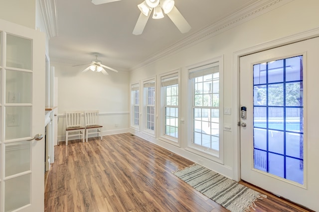 doorway featuring hardwood / wood-style floors, ceiling fan, and crown molding