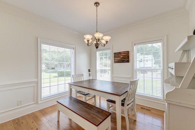 dining space featuring a wealth of natural light, light hardwood / wood-style flooring, and a chandelier