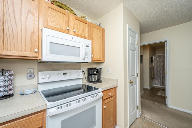 2601 Riverridge Ct Unit A, Moncks Corner, SC 29461 - kitchen featuring white appliances, light countertops, light colored carpet, a textured ceiling, and light tile patterned floors