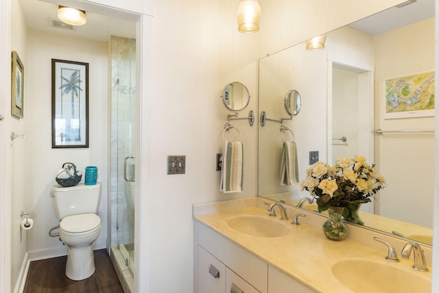 bathroom featuring vanity, toilet, wood-type flooring, and walk in shower