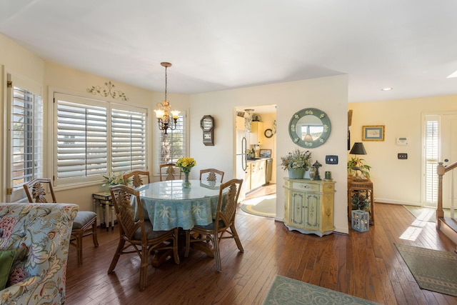 dining area featuring a notable chandelier, plenty of natural light, and dark wood-type flooring