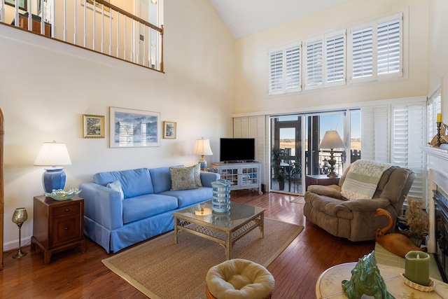 living room featuring a fireplace, a high ceiling, and dark hardwood / wood-style floors