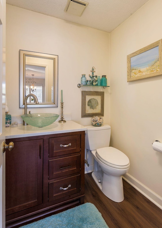 bathroom featuring hardwood / wood-style floors, vanity, a textured ceiling, and toilet