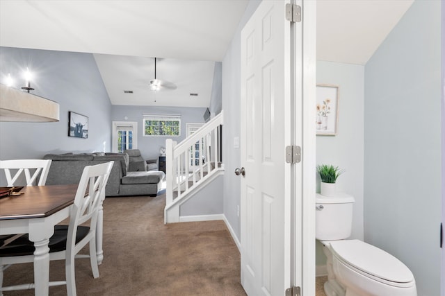 dining area featuring baseboards, stairway, vaulted ceiling, carpet floors, and a ceiling fan