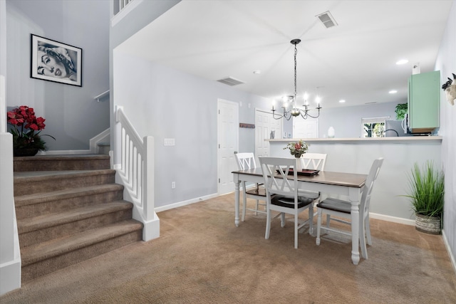 dining room with stairs, an inviting chandelier, carpet, and visible vents