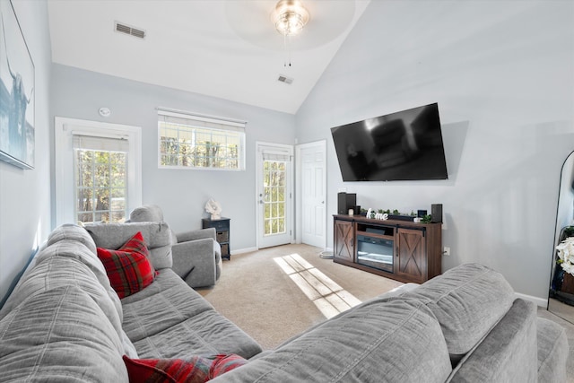 living room featuring visible vents, high vaulted ceiling, baseboards, light colored carpet, and ceiling fan