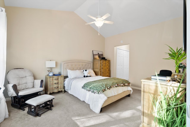 bedroom with a ceiling fan, baseboards, vaulted ceiling, a closet, and light carpet