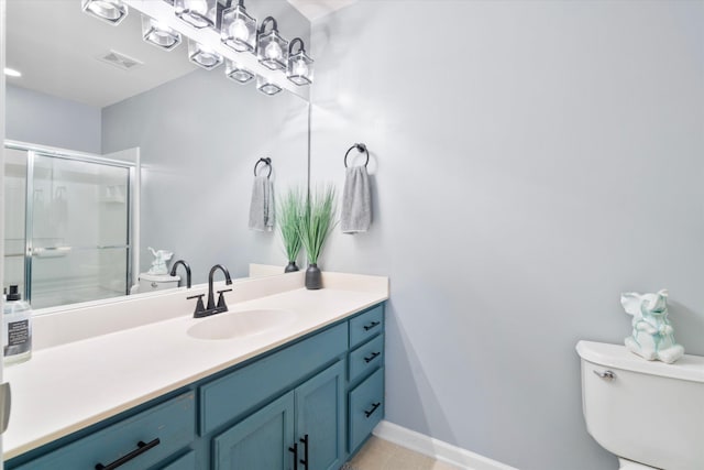 full bath with visible vents, toilet, a stall shower, baseboards, and vanity